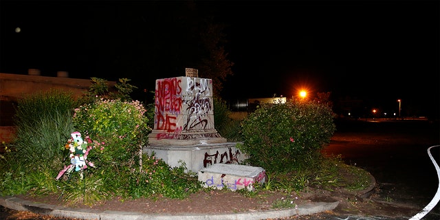 The defaced pedestal where a statue of Christopher Columbus once stood is seen at Byrd Park in Richmond, Va. Tuesday, June 9, 2020. The statue was torn down by protesters, set on fire and then thrown into a lake. News outlets report the figure was toppled less than two hours after protesters gathered in the city’s Byrd Park Tuesday chanting for the statue to be taken down. (Mark Gormus/Richmond Times-Dispatch via AP)