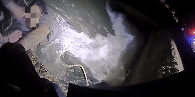 Police officers in Guilford, Connecticut, rescued a man who fell into water while crab fishing and was almost swept into a sluice pipe on Wednesday.