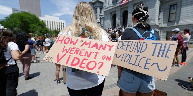 Demonstrators, with signs attached to their packs, gather outside the State Capitol in Denver, Tuesday, June 2, 2020, to protest the death of George Floyd.