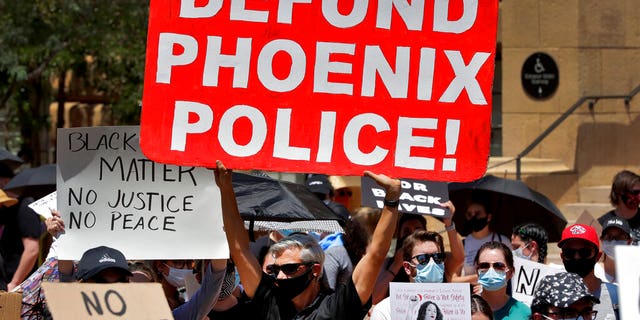 In this June 3, 2020, photo, protesters rally Wednesday, June 3, 2020, in Phoenix, demanding that the Phoenix City Council defund the Phoenix Police Department. (AP Photo/Matt York)