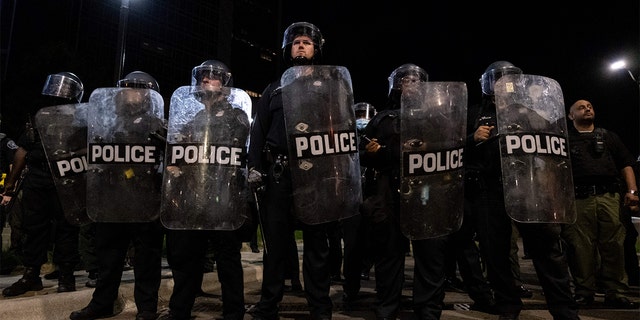 Detroit Police officers watch demonstrators in the city of Detroit, Michigan, on May 29, 2020, over the death of George Floyd, a black man who died after a white policeman knelt on his neck for several minutes. - Violent protests erupted across the United States late on May 29, over the death of a handcuffed black man in police custody, with murder charges laid against the arresting Minneapolis officer failing to quell boiling anger. (Photo by SETH HERALD / AFP) (Photo by SETH HERALD/AFP via Getty Images)