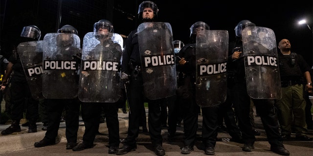 Detroit Police officers watch demonstrators in the city of Detroit, Michigan, on May 29, 2020, over the death of George Floyd, a black man who died after a white policeman knelt on his neck for several minutes. - Violent protests erupted across the United States late on May 29, over the death of a handcuffed black man in police custody, with murder charges laid against the arresting Minneapolis officer failing to quell boiling anger. (Photo by SETH HERALD / AFP) (Photo by SETH HERALD/AFP via Getty Images)