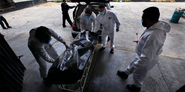 Workers move the body of a COVID-19 victim to the crematorium inside the Panteón San Nicolás Tolentino cemetery in the Iztapalapa neighborhood of Mexico City, Tuesday, June 2, 2020. Funeral parlors and crematoriums in Iztapalapa, a borough of 2 million people, say they have seen their work multiplied with the surging number of dead of COVID-19 in the capital's hardest-hit corner by the new coronavirus. (AP Photo/Marco Ugarte)