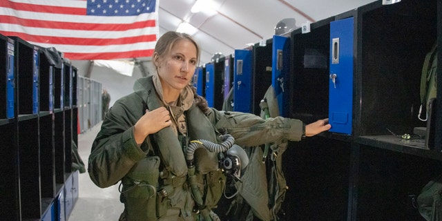 U.S. Air Force Capt. Emily Thompson, 421st Expeditionary Fighter Squadron pilot, dons flight equipment at the Aircrew Flight Equipment shop on Al Dhafra Air Base, United Arab Emirates, June 5, 2020. Thompson is the first female to fly an F-35A Lightning II into combat. She is currently deployed from Hill Air Force Base, Utah.