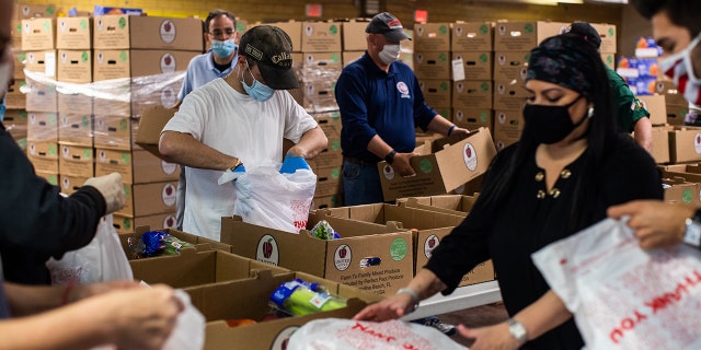 Volunteers wearing protective masks bag groceries at a Catholic Charities Brooklyn and Queens pop-up food pantry in the Brooklyn borough of New York City in May 2020. The pandemic strained food banks and pantries.