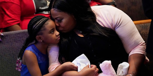 Roxie Washington holds Gianna Floyd, the daughter of George Floyd as they attend the funeral service for George Floyd at The Fountain of Praise church Tuesday, June 9, 2020, in Houston. (AP Photo/David J. Phillip, Pool)