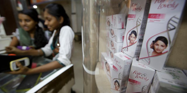 In this file photo, two young women stand at a counter next to a shelf where Hindustan Unilever Ltd. Fair & Lovely beauty products are displayed for sale at a store in Mumbai, India.