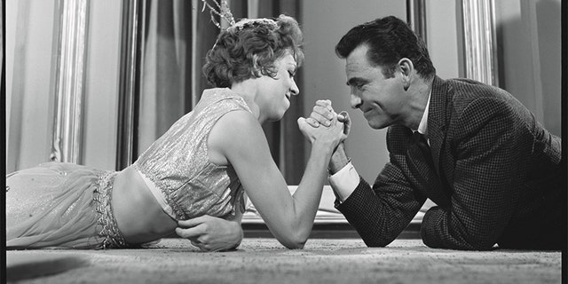 In an off-camera moment, Rod Serling arm wrestles with Carol Burnett.