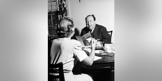 Alfred Hitchcock discussing his movie project with Joan Harrison at his apartment.