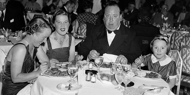 Alfred Hitchcock dining in a New York Restaurant with his wife Alma, his secretary Joan Harrison, and his daughter Patricia.