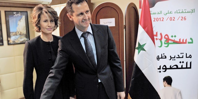 A handout picture released by the Syrian Arab News Agency (SANA) shows Syrian President Bashar al-Assad casting his ballot on the constitution that could end five decades of single-party domination, as his wife Asma looks on at a polling station in Damascus, on February 26, 2012. (AFP via Getty Images)