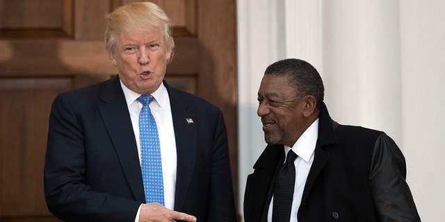 File Photo: President-elect Donald Trump greets Robert Johnson, the founder of Black Entertainment Television, at Trump International Golf Club, November 20, 2016 in Bedminster Township, New Jersey. (Photo by Drew Angerer/Getty Images)
