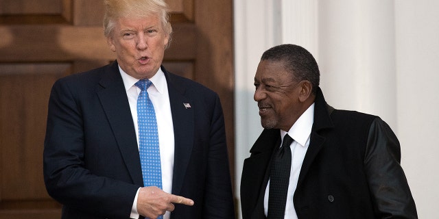 File Photo: President-elect Donald Trump greets Robert Johnson, the founder of Black Entertainment Television, at Trump International Golf Club, November 20, 2016 in Bedminster Township, New Jersey. (Photo by Drew Angerer/Getty Images)