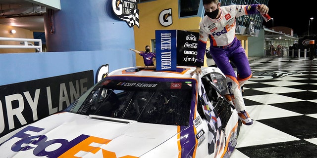 Denny Hamlin jumps from his car after winning a NASCAR Cup Series auto race Sunday, June 14, 2020, in Homestead, Fla. (AP Photo/Wilfredo Lee)