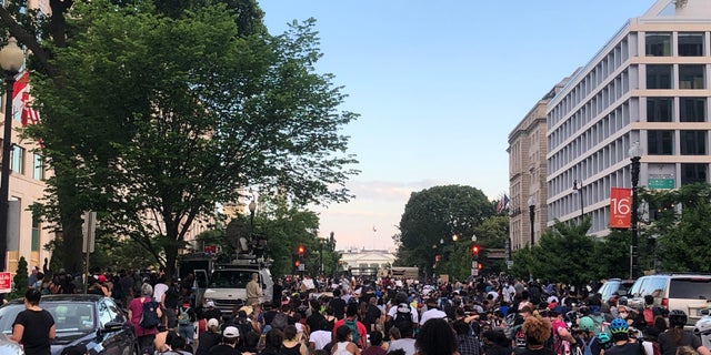 Protesters kneel in front of the White House.