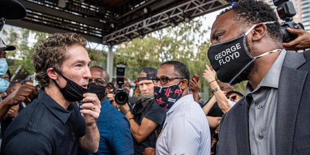 Pastor Joel Osteen greets Lee Meritt, a lawyer for George Floyd's family at a march in honor of George Floyd on June 2, in Houston, Texas. Members of George Floyd's family participated in a march that went from Discovery Green to City Hall with support from the local chapter of Black Lives Matter. (Photo by Sergio Flores/Getty Images)