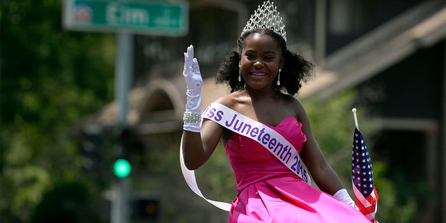 Miss Juneteenth 2015, Sean-Maree Swinger-Otey, 17, waves and joins in as neighbors and visitors line 23rd Ave. in Denver for the 6th annual Park Hill 4th of July Parade with more than 60 entries including the debut of the Park Hill Marching Band and a 16-foot tall replica of the Krishna temple.