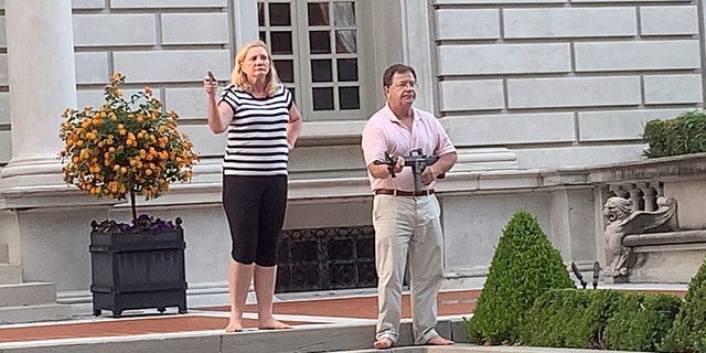 A couple draws their firearms on protestors as they enter their neighborhood during a protest against St. Louis Mayor Lyda Krewson, in St. Louis, Missouri, U.S. June 28, 2020, in this picture obtained from social media. (DANIEL SHULAR/via REUTERS. THIS IMAGE HAS BEEN SUPPLIED BY A THIRD PARTY.)