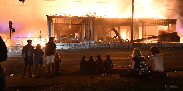 Protesters gather near the Minneapolis Police Third Precinct to watch a construction site burn in the days after the death of George Floyd in Minneapolis, Minn. May 28, 2020. (REUTERS/Nicholas Pfosi)
