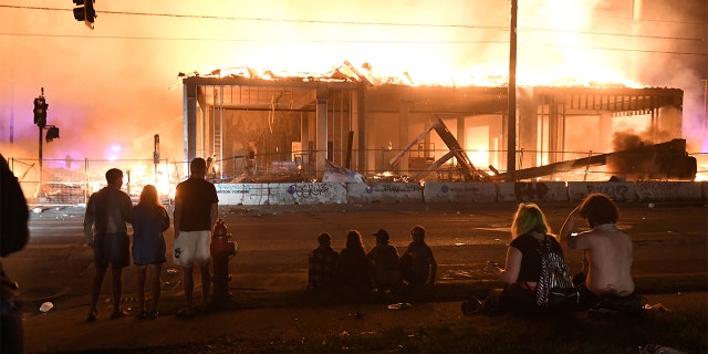 Protesters gather near the Minneapolis Police Third Precinct to watch a construction site burn in the days after the death of George Floyd in Minneapolis, Minn. May 28, 2020. (REUTERS/Nicholas Pfosi)