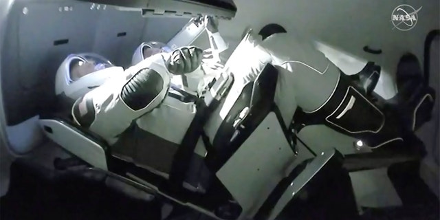 In this image taken from NASA TV video, the SpaceX Dragon crew capsule, with NASA astronauts Doug Hurley, left, and Robert Behnken aboard docks with the International Space Station Sunday, May 31, 2020.