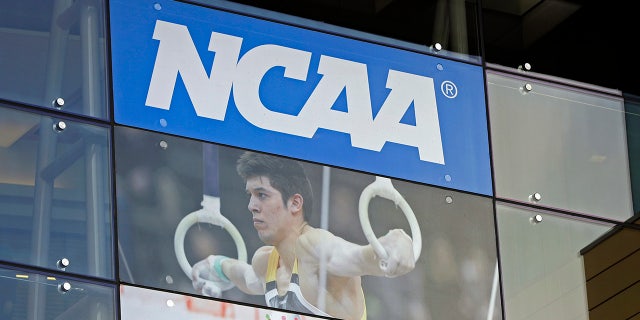 The NCAA logo and a gymnastics photo are seen outside the NCAA headquarters in Indianapolis, April 25, 2018. (Associated Press)