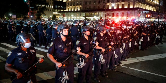 New York Police Department officers stand in formation after arresting multiple protesters marching after curfew on Fifth Avenue, Thursday, June 4, 2020, in New York. Protests continued following the death of George Floyd, who died after being restrained by Minneapolis police officers on May 25. (AP Photo/John Minchillo)