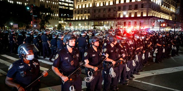 New York Police Department officers stand in formation after arresting multiple protesters marching after curfew on Fifth Avenue, Thursday, June 4, 2020, in New York. (AP Photo/John Minchillo)