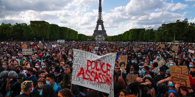 Hundreds of demonstrators gathering on the Champs de Mars as the Eiffel Tower is seen in the background during a demonstration in Paris earlier this month. (AP Photo/Francois Mori, File)