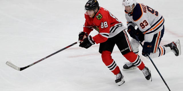 In this March 5, 2020, file photo, Chicago Blackhawks right wing Patrick Kane, left, and Edmonton Oilers center Ryan Nugent-Hopkins chase the puck during the third period of an NHL hockey game in Chicago. Assuming everything goes according to plan and the final details are ironed out between the league and the players' union, the Blackhawks will play the Oilers in a best-of-five qualifier series for the playoff bracket. “It's been a weird three months,” Kane said during a video conference call with reporters. (AP Photo/Nam Y. Huh, File)