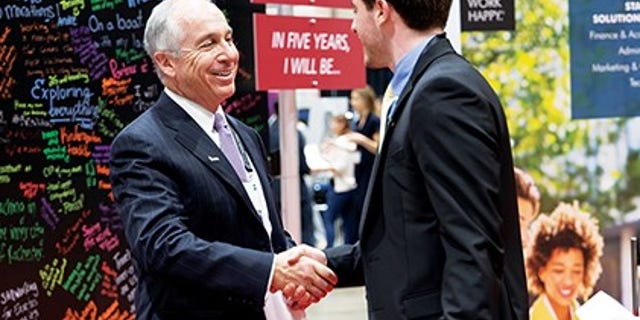 Paul McDonald, senior executive director at Robert Half, greeting a student at an Enactus event. He's been speaking with college grads throughout this time about the current environment and providing tips and tactics for what they should be considering as they enter the job market.