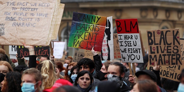 Demonstrators hold signs as they attend a Black Lives Matter protest following the death of George Floyd in Minneapolis police custody, in Newcastle, Britain, June 13, 2020. 