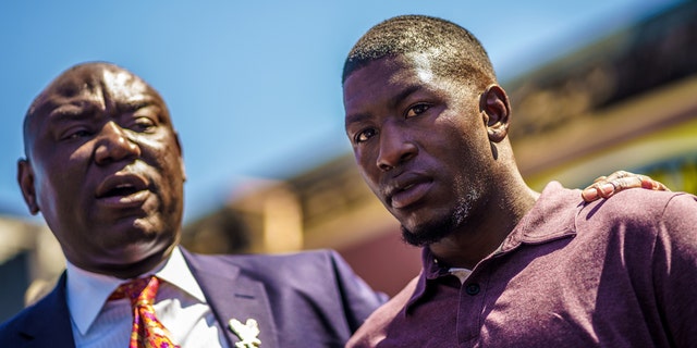 George Floyd's son, Quincy Mason Floyd (R) listens to family Attorney Ben Crump (L) speak to the press, as family members visit the site where George Floyd died, in Minneapolis, Minnesota, on June 3, 2020. (Photo by KEREM YUCEL/AFP via Getty Images)