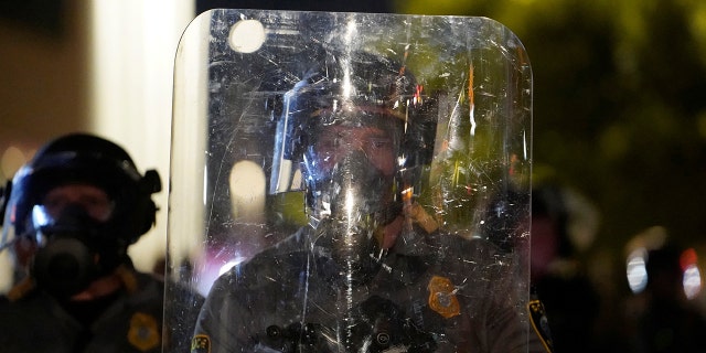 A police officer stands behind a riot shield during nationwide unrest following the death in Minneapolis police custody of George Floyd in Oklahoma City, Okla., U.S., May 31, 2020.