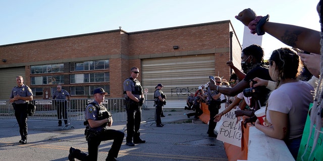 A single officer takes a knee in solidarity with protesters during nationwide unrest following the death in Minneapolis police custody of George Floyd, outside the Oklahoma City Police Department in Oklahoma City, Oklahoma, U.S., May 31, 2020. (Reuters/Nick Oxford)