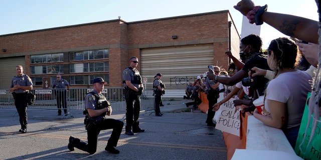 A single officer takes a knee in solidarity with protesters during nationwide unrest following the death in Minneapolis police custody of George Floyd, outside the Oklahoma City Police Department in Oklahoma City, Oklahoma, U.S., May 31, 2020. (Reuters/Nick Oxford)