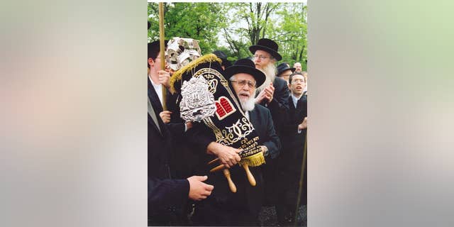 Rabbi Simcha Shafran, father of Rabbi Avi Shafran, carrying a Torah donated to a Baltimore synagogue.