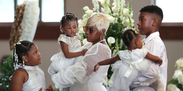 Tomika Miller, the wife of Rayshard Brooks, holding their 2-year-old daughter, Memory, while pausing with her children during the family processional at his funeral in Ebenezer Baptist Church on Tuesday in Atlanta. (Curtis Compton/Atlanta Journal-Constitution via AP, Pool)
