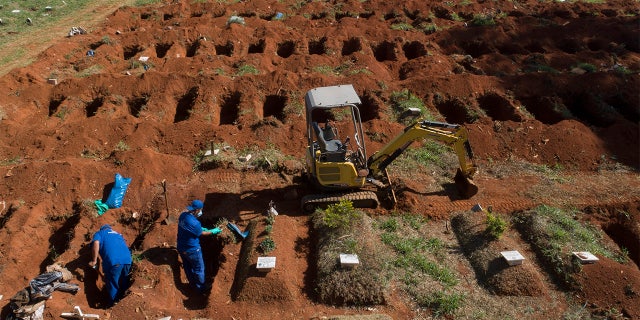 Cemetery workers exhume remains buried three years ago at the Vila Formosa cemetery, which does not charge families for the gravesites, in Sao Paulo, Brazil, Friday, June 12, 2020. Three years after burials, remains are routinely exhumated and stored in plastic bags to make room for more burials, which have increased amid the new coronavirus. (AP Photo/Andre Penner)