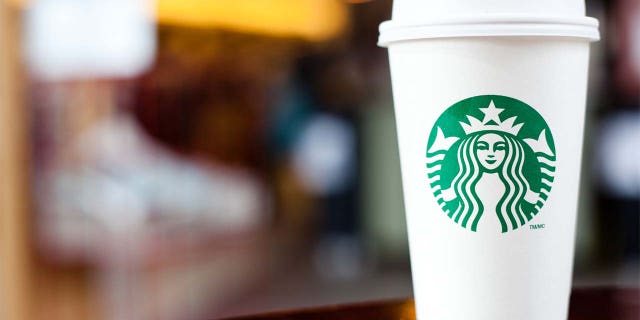 "Halifax, Nova Scotia, Anada - 18 Sep 2011: Grande Starbucks memilih cangkir sambil duduk di meja.  Starbucks adalah waralaba kedai kopi internasional yang sangat populer dengan lebih dari 15.000 lokasi di 50 negara"