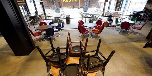 Chairs are stacked on a table inside The Rustic bar in Houston. The restaurant and bar will be limited to 50 percent capacity after Texas Gov. Greg Abbott announced Friday that he is shutting bars back down and scaling back restaurant capacity to 50 percent, in response to the increasing number of COVID-19 cases in Texas. (AP Photo/David J. Phillip)