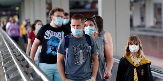 Guests are required to wear facial coverings while inside the parks, although hotel guests will not be required to wear the masks in their hotel pools, and visitors to Volcano Bay, the resort’s water park, are only advised to wear coverings at all times except when swimming, or “going to and from an attraction.” (AP Photo/John Raoux)