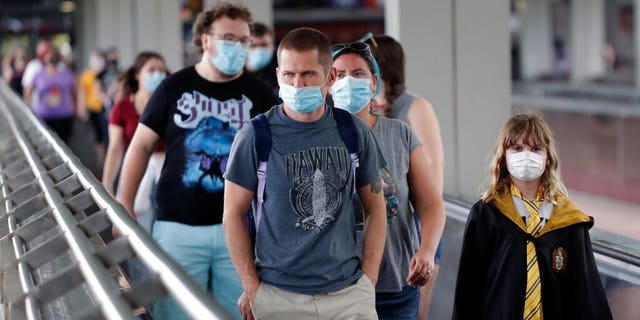 Guests are required to wear facial coverings while inside the parks, although hotel guests will not be required to wear the masks in their hotel pools, and visitors to Volcano Bay, the resort’s water park, are only advised to wear coverings at all times except when swimming, or “going to and from an attraction.” (AP Photo/John Raoux)