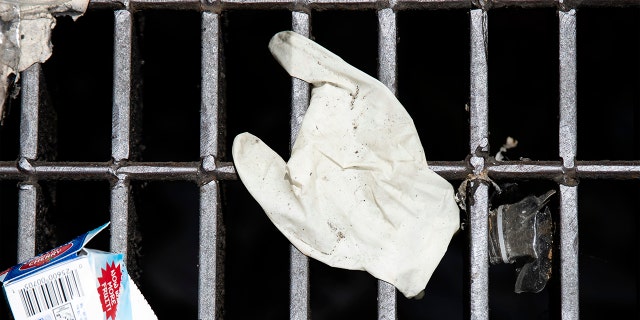 This Monday, May 25, 2020 photo shows a discarded glove on a storm drain in Philadelphia. (AP Photo/Matt Rourke)