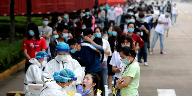 People line up for medical workers to take swabs for the coronavirus test at a large factory in Wuhan in central China's Hubei province on May 15, 2020. (Associated Press)