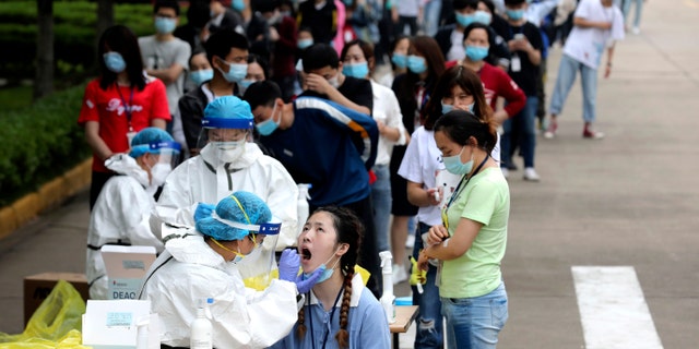 People line up for medical workers to take swabs for the coronavirus test at a large factory in Wuhan in central China's Hubei province on May 15, 2020. (Associated Press)