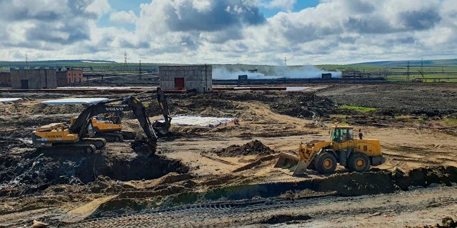 In this June 18, handout photo provided by the Russian Emergency Situations Ministry, workers prepare an area for reservoirs for soil contaminated with fuel at an oil spill outside Norilsk, 1,800 miles northeast of Moscow, Russia.