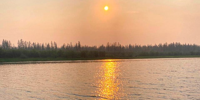 In this handout photo taken June 23, and provided by Olga Burtseva, a beach on the bank of Yana river is empty due to hot weather, during sunset outside Verkhoyansk, the Sakha Republic, about 2,900 miles northeast of Moscow, Russia.