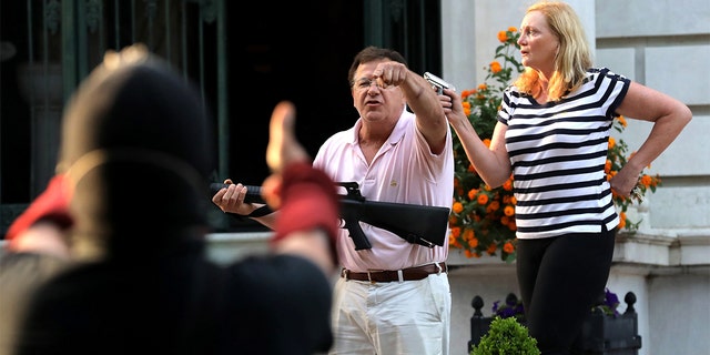 Mark and Patricia McCloskey are seen outside their St. Louis home in a clash with protesters, June 28, 2020. (Getty Images)