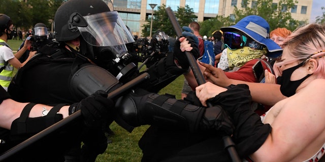 Aurora police officers clash with protesters with batons during the Elijah McClain protest at the Aurora Municipal Center on June 27, 2020. (Photo by Andy Cross/MediaNews Group/The Denver Post via Getty Images)